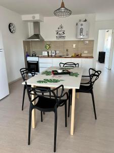 una cucina con tavolo e sedie bianchi in una stanza di APART trelew 5 a Trelew