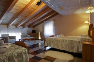 Habitación de hotel con 2 camas y sala de estar. en Hostal Casa Ramón, en Quintanar de la Sierra
