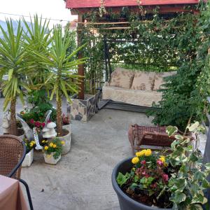 a patio with a couch and some plants and flowers at Bugenvilija in Budva