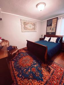 ein Schlafzimmer mit einem blauen Bett und einem Teppich in der Unterkunft Serene Charming Private Suite Patio, Upscale Berkeley in Berkeley