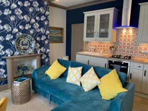 a living room with a blue couch in a kitchen at Elberry at Dart Valley Coastal Apartments in Paignton