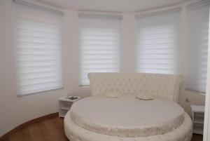 un letto bianco in una stanza con finestre di Castello a Zatonje