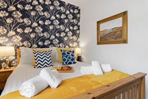 a bedroom with a bed with towels on it at Elberry at Dart Valley Coastal Apartments in Paignton