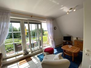 a living room with a large window and a table at Haus Jenny, Wohnung E3b, Sonne rundum in Boltenhagen