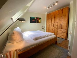 een slaapkamer met een groot bed met een houten hoofdeinde bij Haus Jenny, Wohnung E3b, Sonne rundum in Boltenhagen