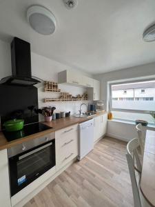 een keuken met witte kasten en een fornuis met oven bij Holyrood Duplex 3- Bedrooms Apartment in Edinburgh