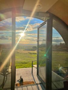 Ballintlea的住宿－Forth Mountain Glamping，一间设有玻璃门的客房,享有田野的景色