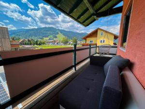 balcón con sofás y vistas a la montaña en Ottl's Appartement O2, en Sankt Lorenzen ob Murau