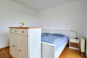 a bedroom with a bed and a white cabinet at Apartment Sun Balcony Dresden Friedrichstadt in Dresden