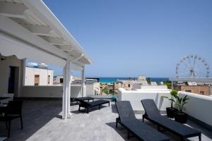 a rooftop patio with chairs and a ferris wheel at B&B il Colibrì in San Vito lo Capo