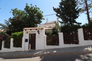 une maison blanche avec un portail et une porte dans l'établissement Castillo Odalbodsol, à Cap de Palos