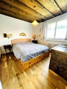 a bedroom with a large bed in a room with wooden ceilings at Cosy Lodge in Madonna di Campiglio