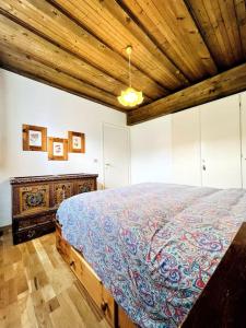 a bedroom with a large bed and a wooden ceiling at Cosy Lodge in Madonna di Campiglio