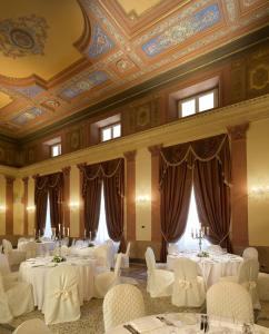 Un salón de banquetes con mesas y sillas blancas. en GH Palazzo Suite & SPA, en Livorno 37 fotos más