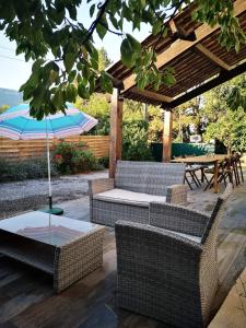 une terrasse avec une table, des chaises et un parasol dans l'établissement Maison 3 étoiles avec jardin pour familles, sportifs, curistes..., à Digne-Les-Bains