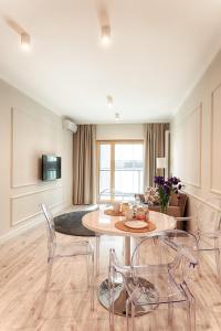 sala de estar con mesa y sillas en Mennica Residence Luxury Location, en Varsovia