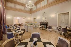 a restaurant with tables and chairs in a room at GH Palazzo Suite & SPA in Livorno