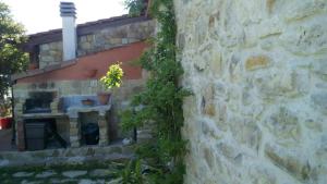 uma parede de pedra com lareira num quintal em Rustico Zagara em Buseto Palizzolo