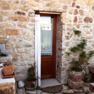 a stone building with a wooden door and a window at Rustico Zagara in Buseto Palizzolo