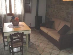 uma sala de estar com uma mesa e um sofá em Rustico Zagara em Buseto Palizzolo