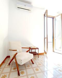 uma sala de estar com uma cadeira e uma mesa em Eco House San Michele em San Michele