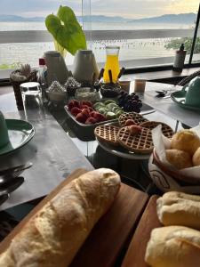 einen Tisch mit einem Tisch mit Speisen und Meerblick in der Unterkunft Villa dos Ganchos in Governador Celso Ramos