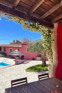 a patio with a table and a tree with flowers at Casa do Lagar - Villa com piscina in Carvalhais