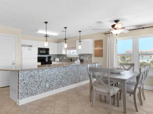a kitchen and dining room with a table and chairs at Emerald Dunes 301 by Newman-Dailey in Destin