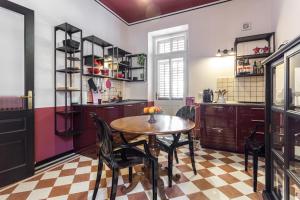 cocina con mesa y sillas en una habitación en La casa di Gatsby lusso in pieno centro con parcheggio, en Gorizia