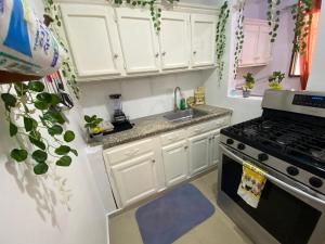 a kitchen with white cabinets and a stove at 8 Santiago Monumental Area Cozy and lovely to enjoy 3 bedrooms Apart transportation 24 hours in Santiago de los Caballeros +76 photos