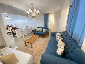 a living room with a blue couch and a table at 8 Santiago Monumental Area Cozy and lovely to enjoy 3 bedrooms Apart transportation 24 hours in Santiago de los Caballeros