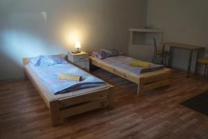 2 łóżka w pokoju z drewnianą podłogą w obiekcie TARNICA w mieście Dwernik