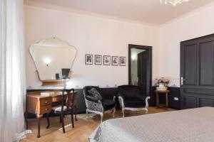 1 dormitorio con 1 cama, escritorio y sillas en La casa di Gatsby lusso in pieno centro con parcheggio, en Gorizia