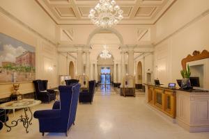 a large lobby with chairs and a chandelier at GH Palazzo Suite & SPA in Livorno