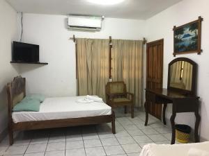a bedroom with a bed and a desk and a mirror at Hotel Ometepetl in Moyogalpa