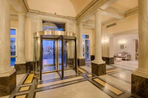 a lobby with a gold elevator in a building at GH Palazzo Suite & SPA in Livorno