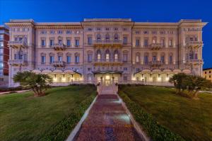 a large building with a pathway in front of it at GH Palazzo Suite & SPA in Livorno