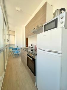 a kitchen with a white refrigerator and a stove at BARIROOMS - Melo Suites in Bari