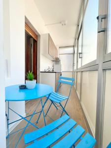 tavolo e sedie blu in una stanza con cucina di BARIROOMS - Melo Suites a Bari