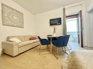 sala de estar con sofá, mesa y sillas en BARIROOMS - Melo Suites en Bari
