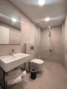 a white bathroom with a sink and a toilet at Amber Boutique Hotel in Cesme