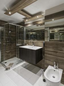 La salle de bains est pourvue d'un lavabo, d'une douche et de toilettes. dans l'établissement Hotel Cervo, à Sils-Maria