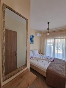 1 dormitorio con espejo grande y cama en Xanthiotis Apartments, en Skala Rachoniou