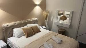 sypialnia z łóżkiem z poduszkami i lustrem w obiekcie Intermezzo2 w mieście Prijepolje