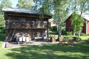 LaukkoskiにあるWilla Mustijokiの庭にテーブルと椅子が備わるログキャビン