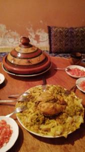 貝爾坎的住宿－GITE TAGMA，一张桌子,上面放着一盘食物,上面放着鸡和米