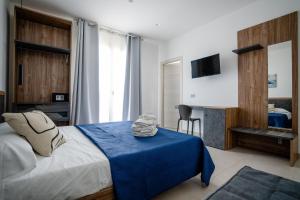 a bedroom with a bed with a blue blanket at B&B il Colibrì in San Vito lo Capo