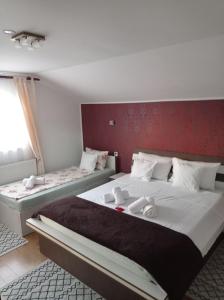 阿爾巴·尤利亞·的住宿－Casa Borza，一间卧室设有两张床和红色的墙壁