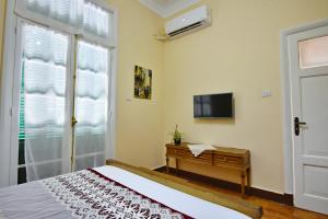 a bedroom with a bed and a tv and a window at The Place 3 charming downtown apartment in Cairo