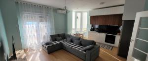 a living room with a couch and a kitchen at Sea View New Apartment in Durrës